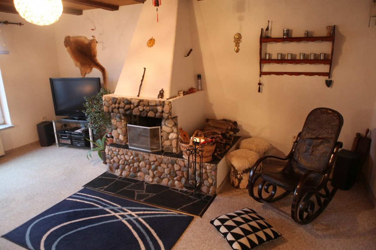 Offener Kamin mit Natursteinverkleidung im Wohnzimmer