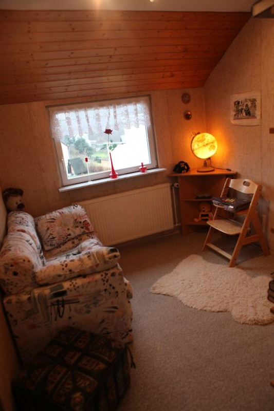 Kinderzimmer mit Sofa, Kinderstuhl und Spielzeug
