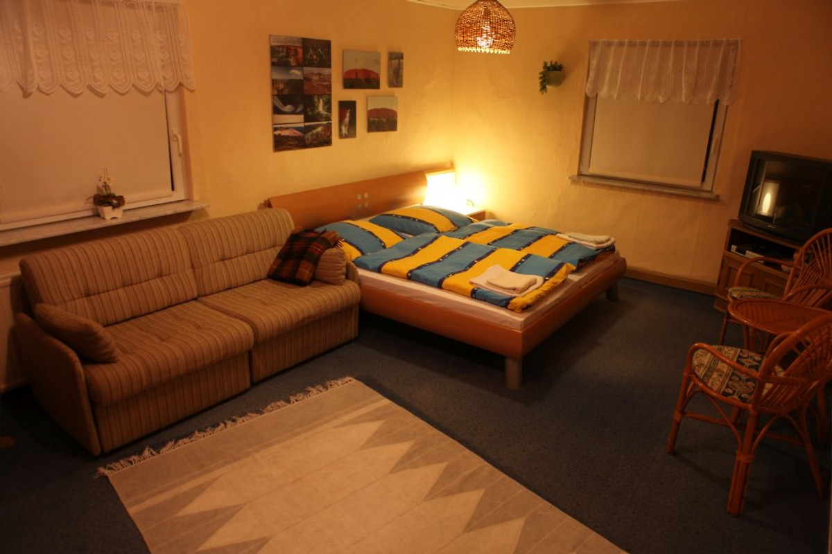 Schlafzimmer EG mit Doppelbett, Sofa und TV