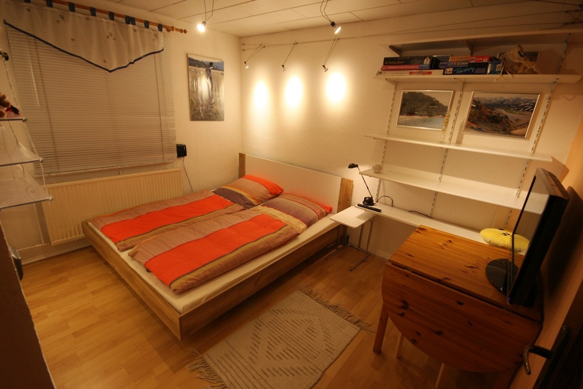 Schlafzimmer EG mit Doppelbett, Nachttischen und TV