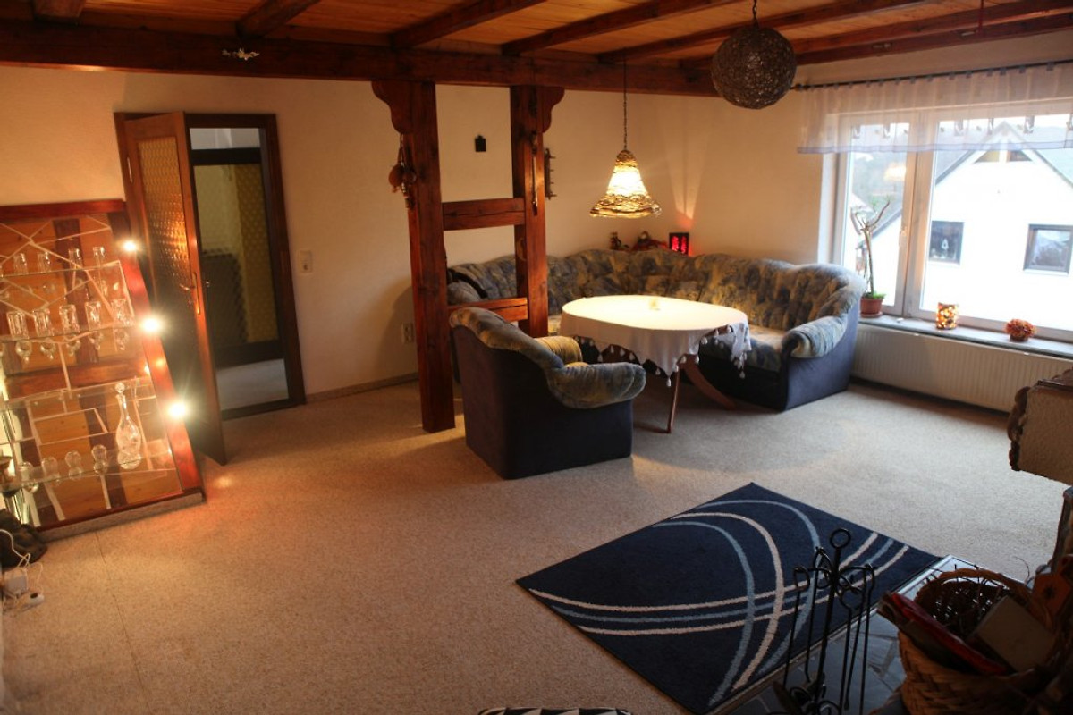 Großes Wohnzimmer mit Holzbalkendecke und Sofa